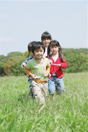 simsearch:695-05777236,k - Children Playing In Grassy Field Fotografie stock - Rights-Managed, Codice: 859-03805818