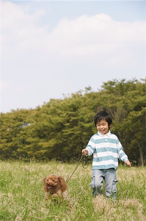 Little Boy Walking With Poodle Dog Fotografie stock - Rights-Managed, Codice: 859-03806227