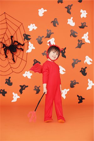 Boy Dressed Up As Devil against Orange Background Foto de stock - Con derechos protegidos, Código: 859-03806342