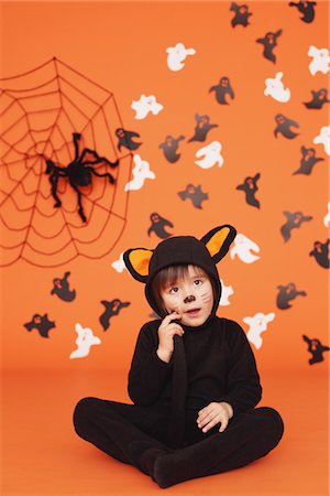 simsearch:859-03806381,k - Garçon en Costume de chat pour Halloween assis sur fond Orange Photographie de stock - Rights-Managed, Code: 859-03806354