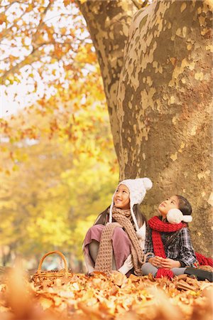 Girls Sitting And Enjoying Near Tree Trunk Stock Photo - Rights-Managed, Code: 859-03839351