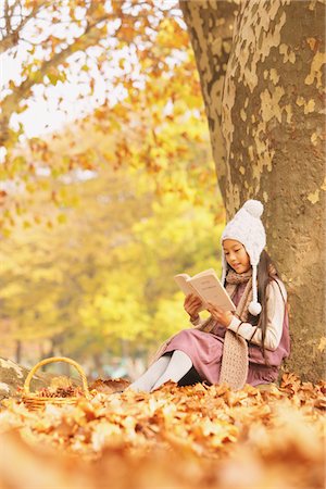 Livre de lecture de fille sous un arbre Photographie de stock - Rights-Managed, Code: 859-03839352