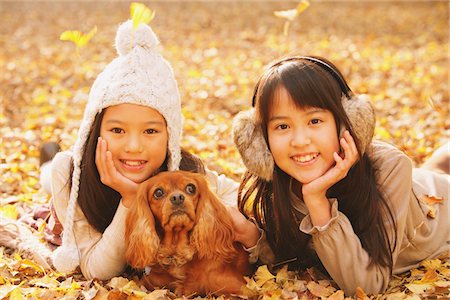 Filles préados couchée dans les feuilles avec chien Photographie de stock - Rights-Managed, Code: 859-03839406