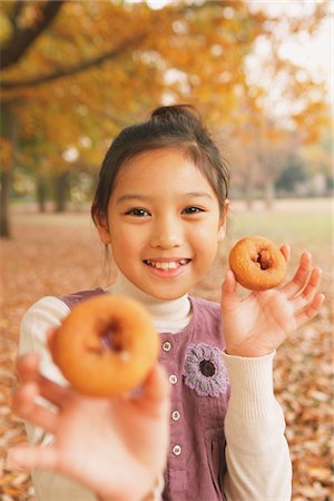 Preteen Girl Looking Holding Bagels Stock Photo - Rights-Managed, Code: 859-03839426