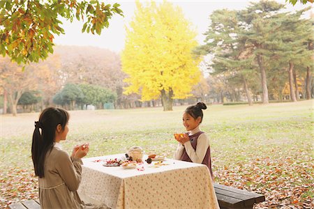 friends eating on table - Girls Having Food In Park Stock Photo - Rights-Managed, Code: 859-03839427