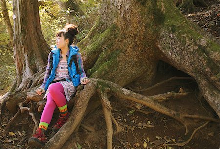 simsearch:859-03860715,k - Young Woman Sitting On Tree Root With Environmental Surroundings Stock Photo - Rights-Managed, Code: 859-03839492