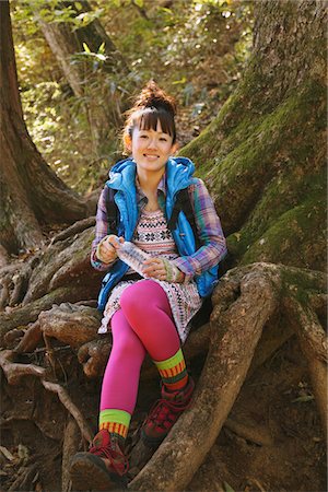 simsearch:859-03860715,k - Young Woman Sitting On Tree Root With Environmental Surroundings Stock Photo - Rights-Managed, Code: 859-03839493