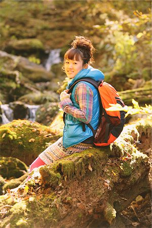 esploratrice - Young Woman Hiker Sitting On Wood Smiling Fotografie stock - Rights-Managed, Codice: 859-03839524