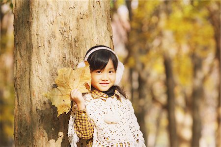 Girl In Autumn Foliage Holding Maple Leaf Stock Photo - Rights-Managed, Code: 859-03839566