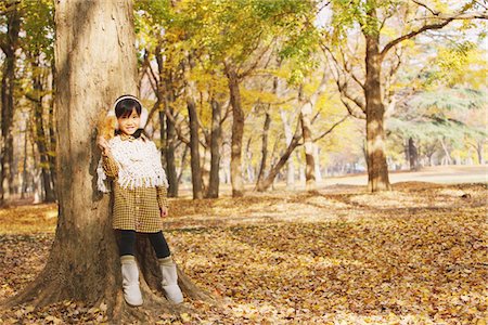 simsearch:622-08139068,k - Jeune fille debout contre un arbre, tenant la feuille d'érable Photographie de stock - Rights-Managed, Code: 859-03839567
