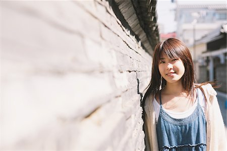 simsearch:859-03885467,k - Jeune fille debout contre un mur en journée ensoleillée Photographie de stock - Rights-Managed, Code: 859-03839955