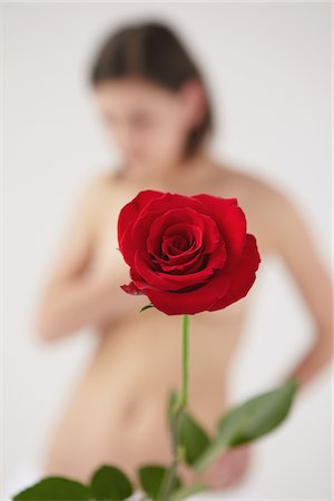 simsearch:614-08874259,k - Rose rouge devant femme floue nue Photographie de stock - Rights-Managed, Code: 859-03839989