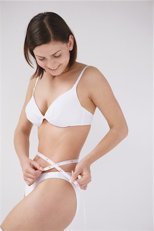A Young Woman Measuring Her Waistline Stock Photo - Rights-Managed, Code: 859-03839995
