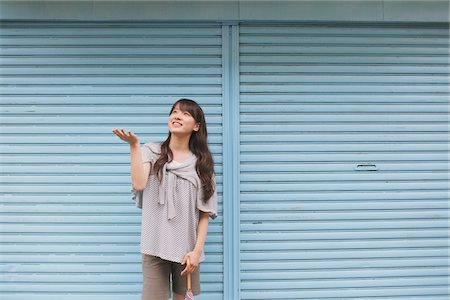 shutters - Young adult woman standing in front of Blue shutter Stock Photo - Rights-Managed, Code: 859-03840095