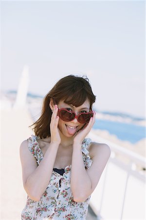 sidewalk blur - Happy Cheerful Young Woman Sticking Tongue Out Stock Photo - Rights-Managed, Code: 859-03840409