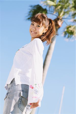 simsearch:859-03860564,k - Young Woman Near A Palm Against Blue Sky Stock Photo - Rights-Managed, Code: 859-03840418