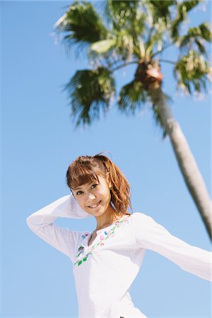 simsearch:859-03730657,k - Young Woman Near A Palm Against Blue Sky Foto de stock - Con derechos protegidos, Código: 859-03840419