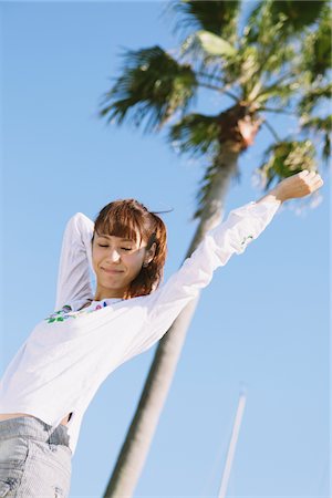 simsearch:859-03860564,k - Young Woman Near A Palm Tree Arm Stretched Stock Photo - Rights-Managed, Code: 859-03840420