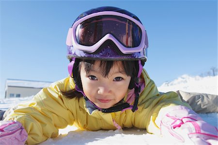 Elementary Age Girl Wearing Ski Suit Lying Down In Snow Stock Photo - Rights-Managed, Code: 859-03840582