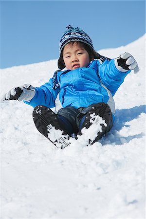 escorregar - Boy Sliding Downward In Snow Foto de stock - Direito Controlado, Número: 859-03840596