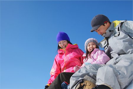 Parents With Their Daughter Sliding Down In Snow Stock Photo - Rights-Managed, Code: 859-03840627