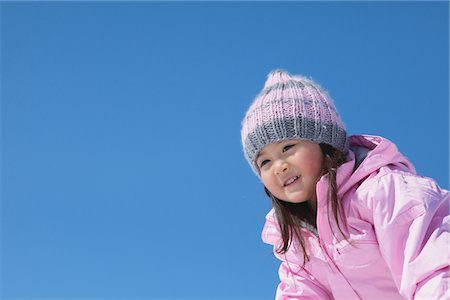 entrañable - Happy Small Girl Against Blue Sky Foto de stock - Con derechos protegidos, Código: 859-03840646