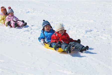 Children Sledging In Snow Foto de stock - Direito Controlado, Número: 859-03840698
