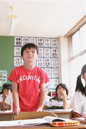 Japanese Schoolboy Answering In Classroom Foto de stock - Con derechos protegidos, Código: 859-03860788