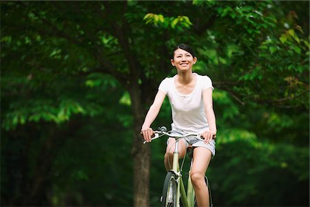 Japanese Woman Smiling and Cycling In Park Foto de stock - Con derechos protegidos, Código: 859-03884508