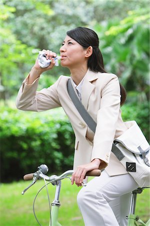 simsearch:693-06403501,k - Businesswoman Drinking Water Whilst Riding Bicycle Stock Photo - Rights-Managed, Code: 859-03884532