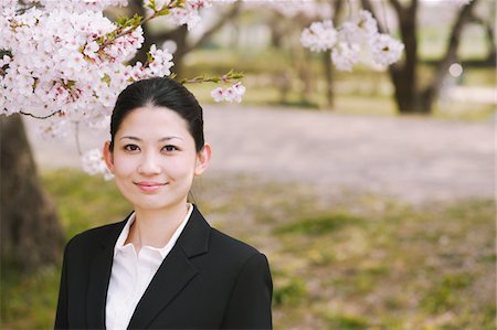 Businesswoman Standing In Field Of Cherry Blossom Tree Pointing Up Stock Photo - Rights-Managed, Code: 859-03884976