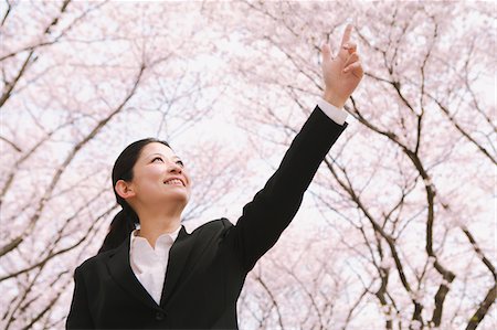 simsearch:622-06191361,k - Businesswoman Standing Under Cherry Trees And Pointing Up Stock Photo - Rights-Managed, Code: 859-03884971