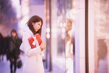 Japanese Women Holding Christmas Gift And Looking Down Stock Photo - Rights-Managed, Code: 859-03982512