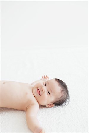 Six Month Old Baby Smiling And Lying On Back Foto de stock - Con derechos protegidos, Código: 859-03982750