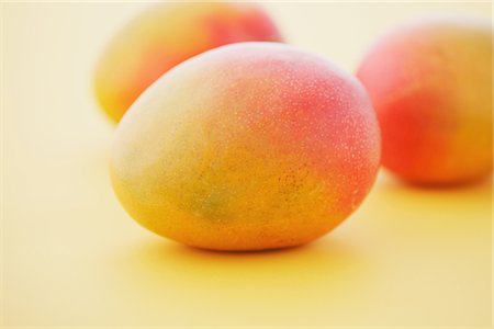 Three Apple Mangoes On Yellow Background Stock Photo - Rights-Managed, Code: 859-03982994