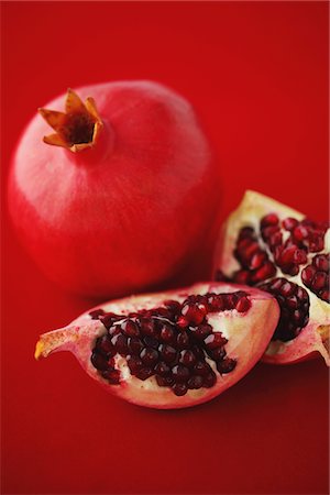Whole And Sliced Pomegranate On Red Background Foto de stock - Con derechos protegidos, Código: 859-03983065