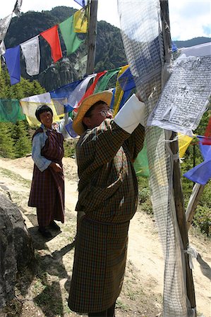 People hanging prayer flags in Bhutan,Taktshang Goemba Tigers Nest Monastery,Bhutan Stock Photo - Rights-Managed, Code: 851-02958821