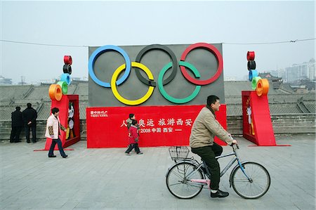 pedestrian side - A local man rides past an Olympic display by the Old City wall,Xian,Xi'an,Capital of Shaanxi Province,China Stock Photo - Rights-Managed, Code: 851-02959148