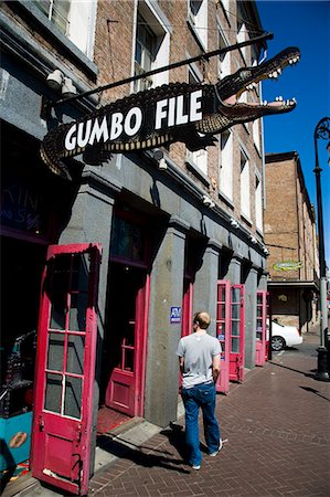 A man walks past a crocodile shaped sign for Gumbofile,a cafe bar,in the French Quarter,New Orleans,Louisiana,USA Stock Photo - Rights-Managed, Code: 851-02964179