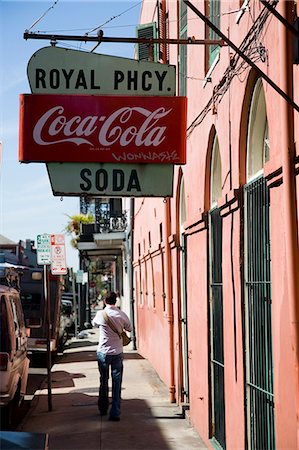 simsearch:851-02964181,k - Backview of man walking along city street with old, store sign hanging down from building, USA Foto de stock - Direito Controlado, Número: 851-02964187