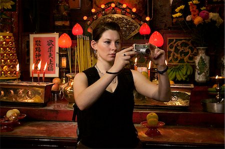 Young woman taking photographs standing inside temple,Yau Ma Tei,Kowloon,Hong Kong,China Foto de stock - Con derechos protegidos, Código: 851-02960141