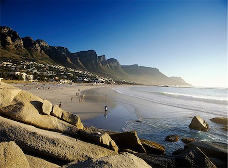 simsearch:851-02962551,k - Menschen, die in der Abenddämmerung mit den 12 Aposteln hinter, Cape Town, Südafrika Camps Bay Strand entlang wandern. Stockbilder - Lizenzpflichtiges, Bildnummer: 851-02962543