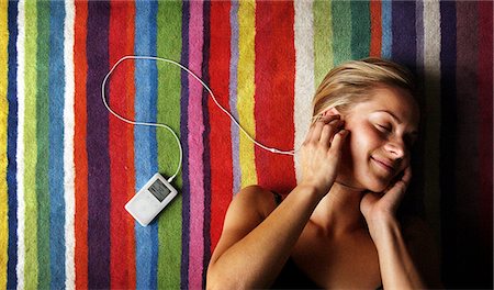 Jeune femme à l'écoute d'un ipod Apple. Photographie de stock - Rights-Managed, Code: 851-02963365