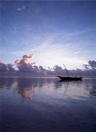 Boutre dans des eaux calmes à marée basse à l'aube, plage de Matemwe, Zanzibar, Tanzanie. Photographie de stock - Rights-Managed, Code: 851-02963361