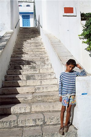 Boy standing on steps,Tunisia Foto de stock - Con derechos protegidos, Código: 851-02963572