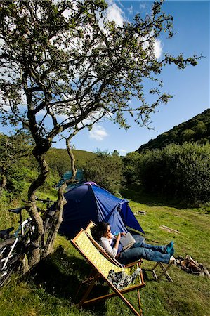 simsearch:851-02963985,k - Camper femme assis sur la chaise longue lecture, nuage Farm camping North Devon, Exmoor, Royaume-Uni Photographie de stock - Rights-Managed, Code: 851-02963801