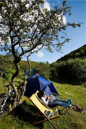 simsearch:851-02963716,k - Female camper sat on deck chair reading,Cloud Farm Campsite North Devon,Exmoor,UK Foto de stock - Con derechos protegidos, Código: 851-02963801