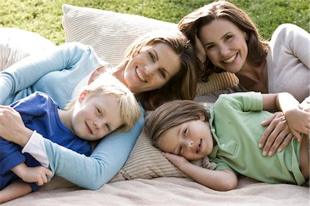 Two happy women with two children on blanket outdoors Foto de stock - Con derechos protegidos, Código: 853-05523416