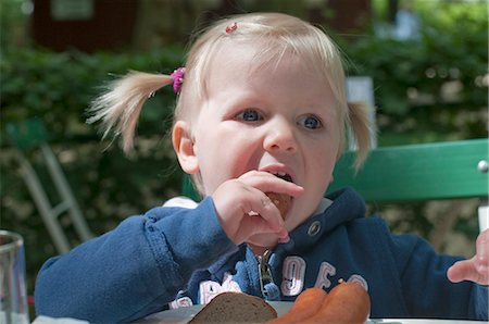 eat meat - Girl eating sausage Stock Photo - Rights-Managed, Code: 853-05523509