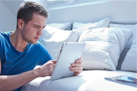 sitting room with people sitting - Young man with ipad Stock Photo - Rights-Managed, Code: 853-05523636